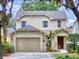 Two-story house with a beige exterior, two-car garage, and manicured lawn at 107 Littleton Cir, Deland, FL 32724