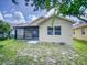 Tan house exterior with screened patio and landscaping at 107 Littleton Cir, Deland, FL 32724