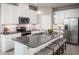 Island kitchen with granite countertops, white cabinets, and stainless steel appliances at 814 Canyon Creek Dr, New Smyrna Beach, FL 32168