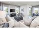 Living room with white sofas, gray armchairs, and a view to backyard at 814 Canyon Creek Dr, New Smyrna Beach, FL 32168