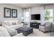 Living room featuring white sofas, a dark wood media console, and a plush ottoman at 814 Canyon Creek Dr, New Smyrna Beach, FL 32168