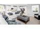 Open living room with white couch, ottoman, and kitchen view at 1299 Whispering Ln, Minneola, FL 34715
