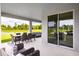 Spacious covered patio with wicker furniture and serene backyard view at 1299 Whispering Ln, Minneola, FL 34715