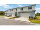 Three-unit townhome building with attached garages and landscaping at 6923 Five Oaks Dr, St Cloud, FL 34773