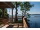 Relaxing lakeside deck with wooden swing overlooking tranquil waters at 6923 Five Oaks Dr, St Cloud, FL 34773