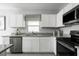 Modern kitchen with white cabinets, granite countertops, and stainless steel appliances at 1337 Laramie Way, Haines City, FL 33844