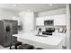 Modern kitchen features stainless steel appliances and a large island with seating at 1602 Minnesota Rd, Sumterville, FL 33585