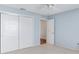 Bright bedroom with light blue walls, carpet flooring, and spacious closet at 1052 Ridgeville Rd, The Villages, FL 32162