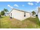 Tan vinyl-sided house with a grassy backyard at 1052 Ridgeville Rd, The Villages, FL 32162