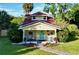 Charming yellow house with red roof, porch, and landscaped yard at 104 Sunset Way, Fruitland Park, FL 34731