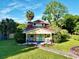 Charming yellow house with red roof, landscaped yard, and walkway at 104 Sunset Way, Fruitland Park, FL 34731