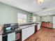 Bright kitchen with white cabinets, dark countertops, and a view of the living room at 104 Sunset Way, Fruitland Park, FL 34731
