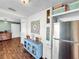 Kitchen with stainless steel refrigerator, blue cabinet, and wood floors at 104 Sunset Way, Fruitland Park, FL 34731