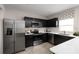 Modern kitchen with dark cabinetry, stainless steel appliances, and white countertops at 1653 Laia Rd, Haines City, FL 33844