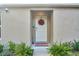 White front door adorned with a festive wreath, welcome mat, and landscaping at 15138 Sw 50Th Avenue Rd, Ocala, FL 34473