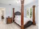 Bedroom with a four-poster bed and wood floors at 1910 E Pollock Rd, Lakeland, FL 33813
