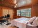 Bedroom with wood paneled walls, large bed, and home office space at 1910 E Pollock Rd, Lakeland, FL 33813