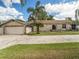 Ranch home with stone exterior, attached garage, and a spacious yard at 1910 E Pollock Rd, Lakeland, FL 33813