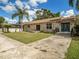 Charming stone house with a new dark blue front door and a walkway at 1910 E Pollock Rd, Lakeland, FL 33813