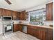 Rustic kitchen with wooden cabinets, stainless steel appliances, and light flooring at 1910 E Pollock Rd, Lakeland, FL 33813