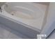 Modern bathroom with a built-in bathtub and tiled walls at 5537 Misty Oak Cir, Davenport, FL 33837