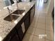 Modern kitchen with double stainless steel sink, dark cabinets, and granite countertops at 5537 Misty Oak Cir, Davenport, FL 33837