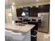 Modern kitchen with stainless steel appliances, granite countertops, and dark wood cabinets at 5537 Misty Oak Cir, Davenport, FL 33837