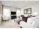 Bright living room featuring white sofas, a large TV, and stylish decor at 10865 Sw 73Rd Ct, Ocala, FL 34476