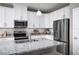 Modern kitchen with white cabinets, stainless steel appliances, and granite countertops at 10918 Sw 73Rd Ct, Ocala, FL 34476