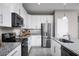 Modern kitchen with white cabinets, stainless steel appliances, and granite countertops at 10918 Sw 73Rd Ct, Ocala, FL 34476