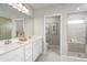 Elegant bathroom with double vanity, large mirror, and a walk-in shower at 10937 Sw 73Rd Ct, Ocala, FL 34476