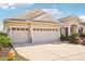 Three-car garage with tan exterior and driveway at 5631 Superior Dr, Lakeland, FL 33805
