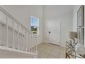 Bright and spacious entryway with staircase and view to kitchen at 2201 Lelani Cir, Davenport, FL 33897