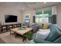 Living Room with teal couch and large TV at 177 Bella Verano Way, Davenport, FL 33897