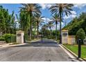 Gated community entrance with palm trees and stone pillars at 779 Stephens Pass Cv, Lake Mary, FL 32746