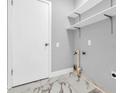 Modern laundry room with white cabinets and marble-look flooring at 1502 Ne Buckeye Ne Rd # 2, Winter Haven, FL 33881