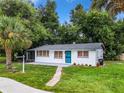 Newly renovated home with a landscaped yard and teal door at 227 W 7Th St, Apopka, FL 32703