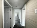 Long hallway with gray walls, white doors, and gray-toned wood-look flooring at 2808 Fletcher Ave, Lakeland, FL 33803