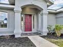 Inviting front entry with a burgundy door and a slate tile walkway at 518 Marion Oaks Trl, Ocala, FL 34473