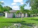 Gray house with a green lawn and palm trees at 5337 Jacob Ave, Polk City, FL 33868