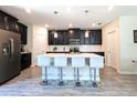 Modern kitchen with dark cabinetry, quartz countertops, and island with seating at 2905 Black Birch Dr, Ocoee, FL 34761