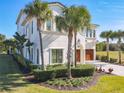 Two-story house with stucco siding, palm trees, and a three-car garage at 550 Muirfield Loop, Reunion, FL 34747