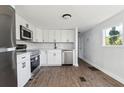 Modern kitchen featuring white cabinets, stainless steel appliances, and wood-look flooring at 18925 3Rd Ave, Orlando, FL 32820