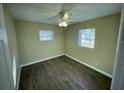 Cozy bedroom with wood-look flooring, ceiling fan, and large windows at 7204 Peyton Pl, Orlando, FL 32818
