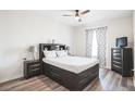 Bedroom with a dark wood bedframe, matching nightstands, dresser and ceiling fan at 7664 Comrow St # 305, Kissimmee, FL 34747