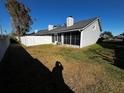 Backyard with screened porch, white fence, and grassy area at 4520 Summergrove Ave, Orlando, FL 32812