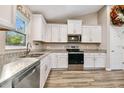 Modern kitchen featuring white cabinets, granite countertops, and stainless steel appliances at 20304 Sw 75Th St, Dunnellon, FL 34431