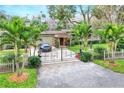 Home exterior featuring gated entrance, landscaping, and palm trees at 24120 Mink Rd, Astor, FL 32102