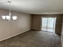 Bright living room featuring neutral carpeting and a chandelier at 333 Lake Howard Nw Dr # 202C, Winter Haven, FL 33880