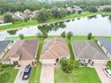 Aerial view of houses near a lake, several with solar panels at 4814 Rockvale Dr, Kissimmee, FL 34758